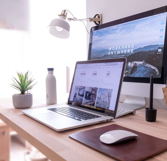 MacBook Pro on table beside white iMac and Magic Mouse